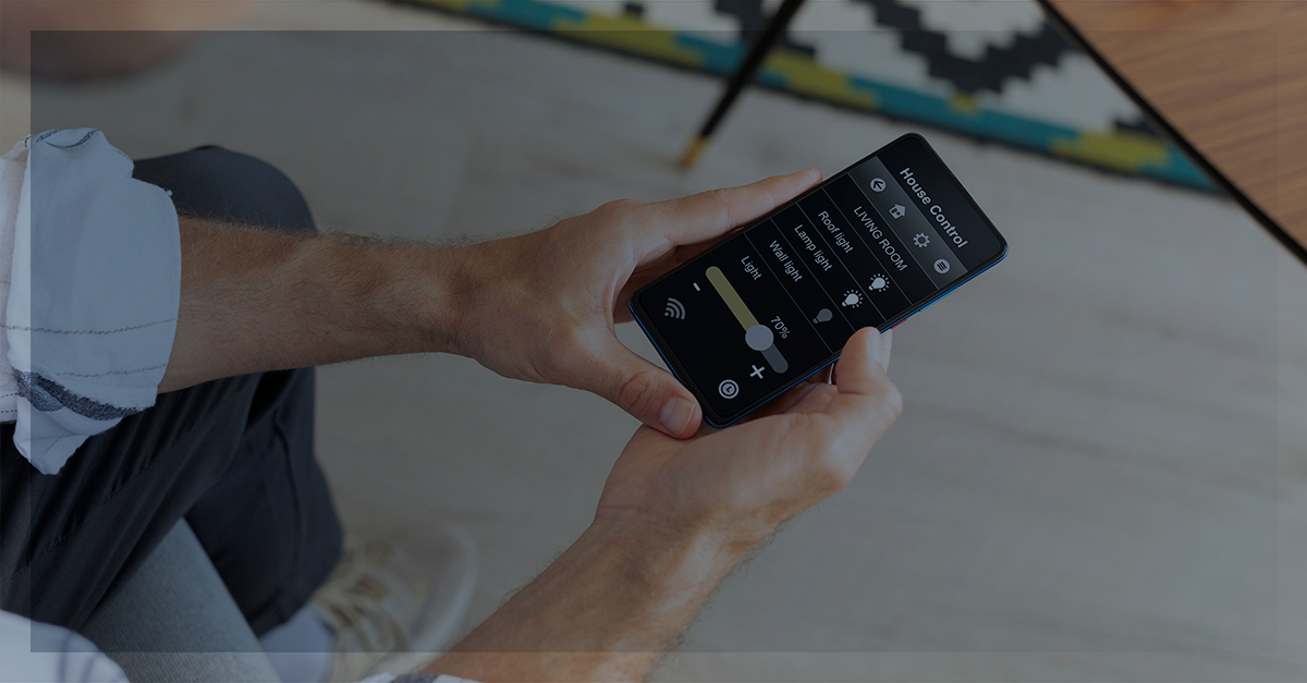 Homem sentado olhando para a tela do celular com um aplicativo aberto | Como funciona a autenticação de dois fatores.