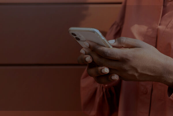 Mulher vestindo um moletom rosa mexendo no Celular | quipamento corporativo ser roubado ou furtado