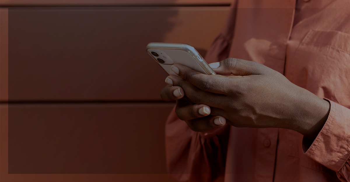 Mulher vestindo um moletom rosa mexendo no Celular | quipamento corporativo ser roubado ou furtado