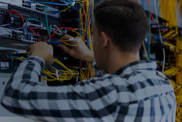 Homem na sala de servidores realizando manutenção na rede | Outsourcing: como ele pode ajudar a área de TI