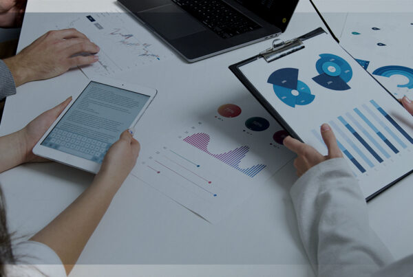 Pessoas trabalhando com gráficos em uma mesa, representando a análise preditiva.