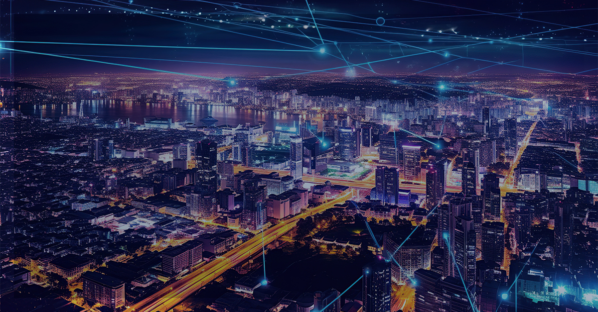 Vista aérea de uma cidade iluminada à noite, com feixes de luz azul representando conexões digitais, simbolizando a expansão da internet com o IPv6.