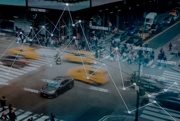 Cena urbana movimentada com táxis amarelos e pedestres em um cruzamento, sobreposta por gráficos digitais e números, ilustrando a transformação do transporte público com tecnologia.
