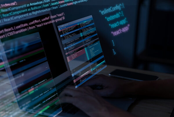 Pessoa digitando em um notebook com várias janelas de código flutuando sobre a tela, destacando uma interface de programação em ambiente de desenvolvimento moderno.