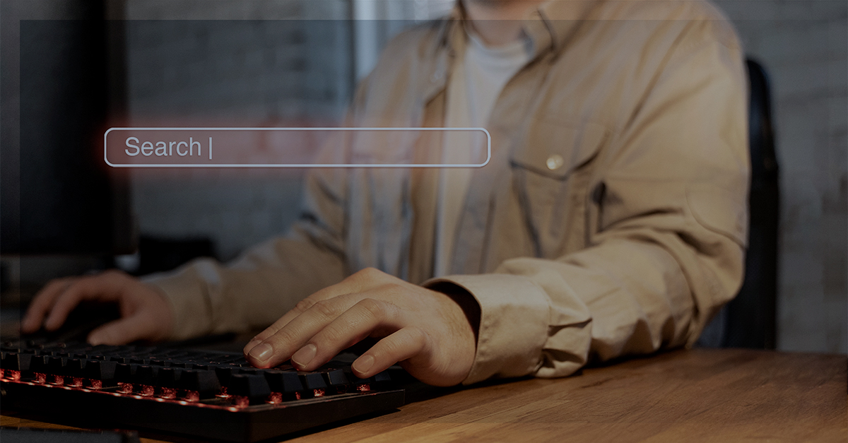 Pessoa digitando em um teclado com uma interface de barra de pesquisa flutuando à frente, sugerindo a escolha de um navegador de acordo com sua necessidade.