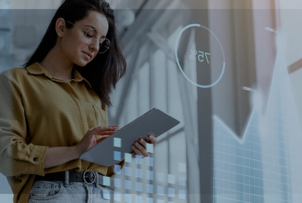 Mulher jovem com óculos e camisa amarela usando um tablet, sobreposição de gráficos digitais e barra de progresso circular mostrando 75%, representando digitalização, automação e análise de dados.