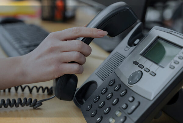 Telefone corporativo em uso, simbolizando comunicação empresarial eficiente e soluções em telecomunicações.