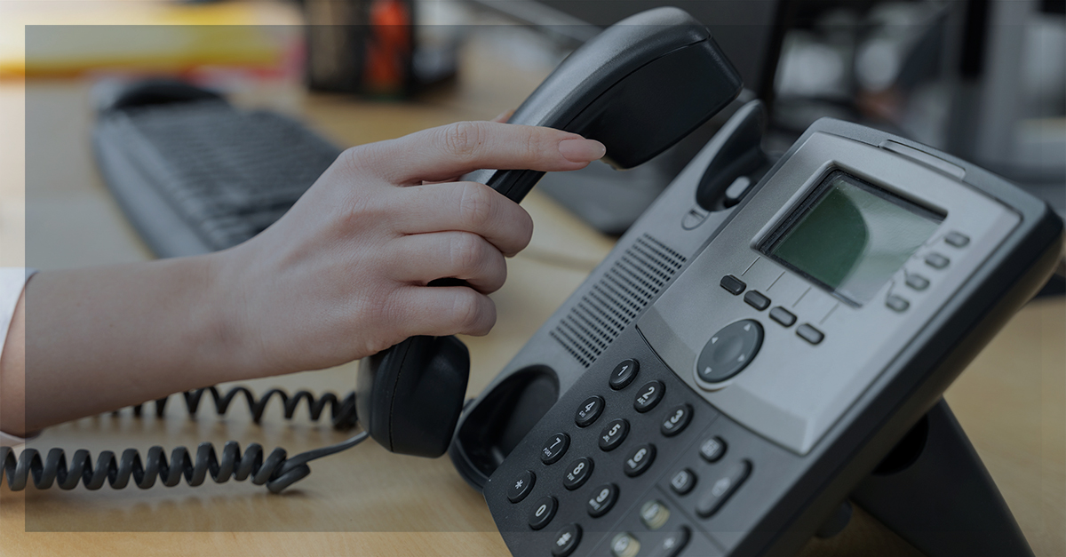 Telefone corporativo em uso, simbolizando comunicação empresarial eficiente e soluções em telecomunicações.