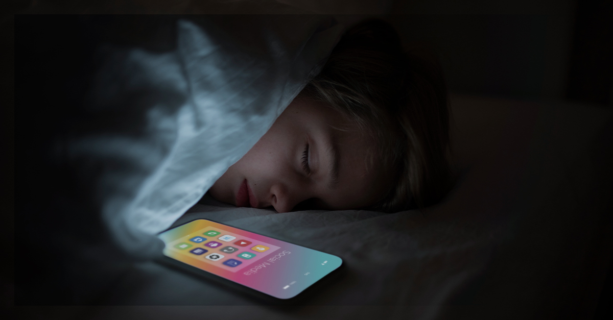 Criança dormindo ao lado de um celular, refletindo os impactos da hiperconectividade e do uso excessivo de tecnologia na saúde mental.