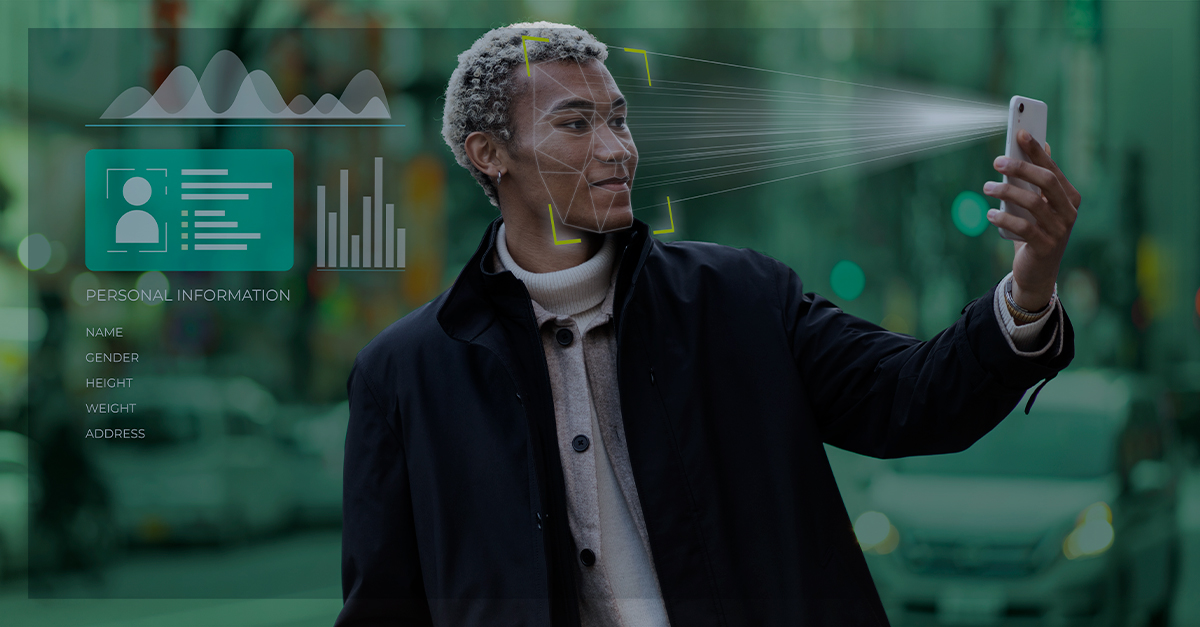 Pessoa segurando o celular em frente ao rosto enquanto o aparelho faz reconhecimento facial, com gráficos e informações pessoais sobrepostos representando coleta de dados por inteligência artificial.