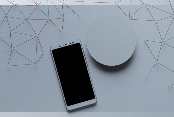 Smartphone branco sobre uma superfície clara com linhas formando uma rede minimalista ao fundo, representando conexão e minimalismo digital.