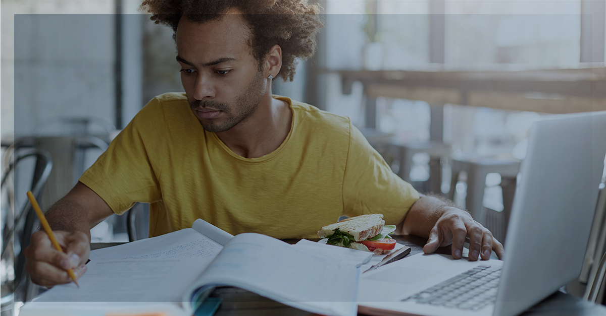 IA no dia a dia: pessoa estudando com caderno aberto e notebook, fazendo anotações para trabalho e estudos.